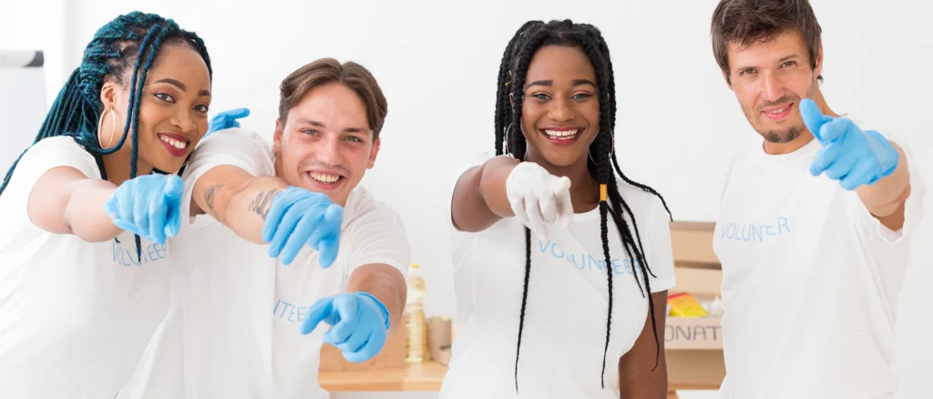 grupo de voluntarios apuntando frente ellos - Caribbean Cleaning Srq